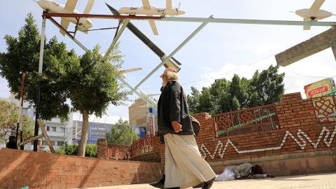 Yemenis walk past an installation depicting military drones in Sanaa on November 16, 2023, amid ongoing battles between Israel and the Palestinian group Hamas in the Gaza Strip. Yemen's Huthi rebels on November 13, threatened to target Israeli ships in the Red Sea, as the group said they had launched another missile targeting the country over its war with Hamas. (Photo by MOHAMMED HUWAIS / AFP) (Photo by MOHAMMED HUWAIS/AFP via Getty Images)