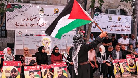 A man waves a Palestinian flag in the West Bank on July 9, 2024. (Zain Jaafar/AFP via Getty Images)