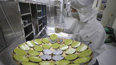 An employee processes chips at a workshop of Jiangsu Aoyang Shunchang Photoelectric Technology Co., Ltd. on May 11, 2024 in Huaian, Jiangsu Province of China. (Photo by Zhao Qirui/VCG via Getty Images)