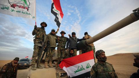 Iraqi paramilitaries of Asa'ib Ahl al-Haq wave their flag and the national flag on November 25, 2017. (Ahamad al-Rubaye/AFP via Getty Images)