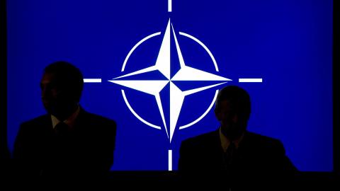 Participants sit in front of the NATO logo during the NATO summit in Newport, South Wales, on September 4, 2014. (Maurizio Gambarini via Getty Images)