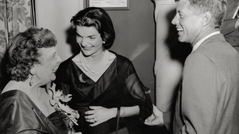 Senator and Mrs. John Kennedy are greeted by Perle Mesta. (Getty Images) 